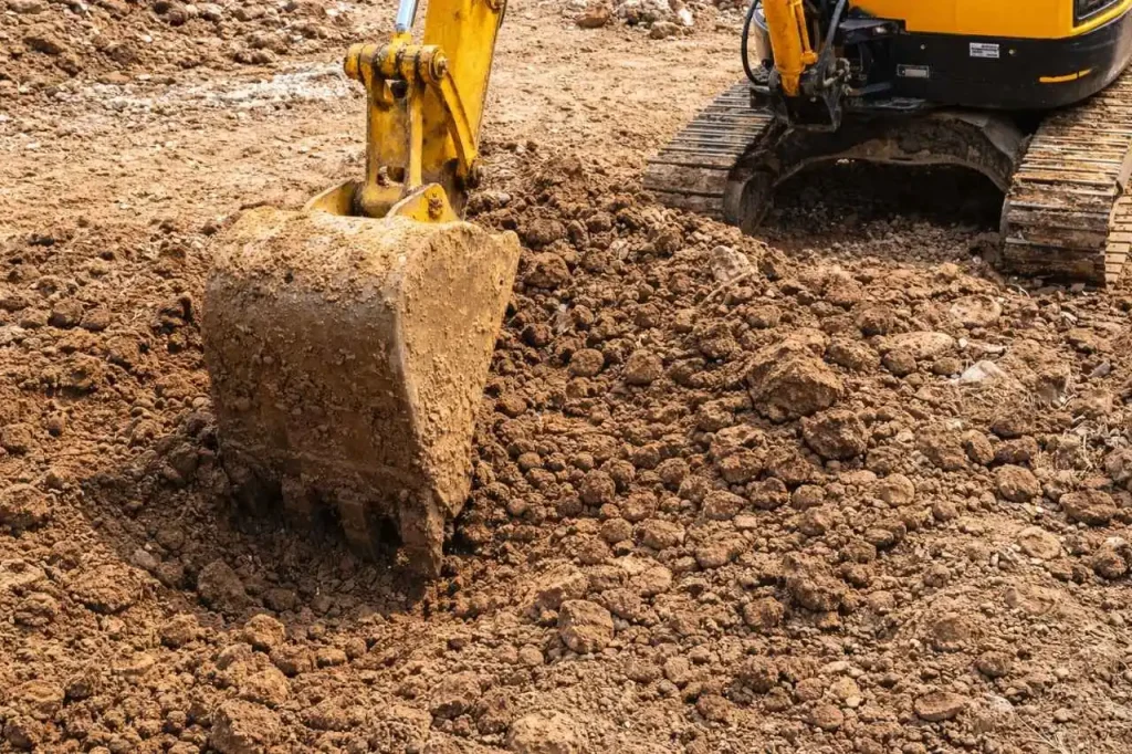 Excavator bucket breaking and moving soil during bulk earthworks excavation in Epping Victoria construction site.