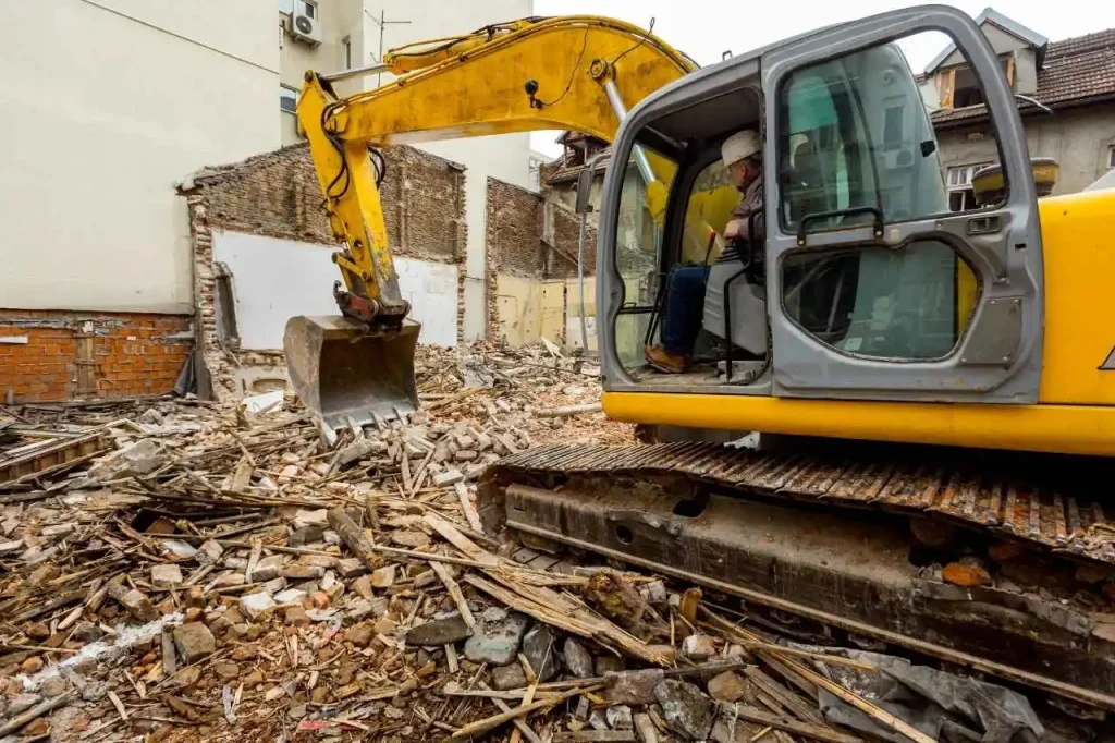 Excavator demolishing commercial building structure with debris on site in Brighton VIC.