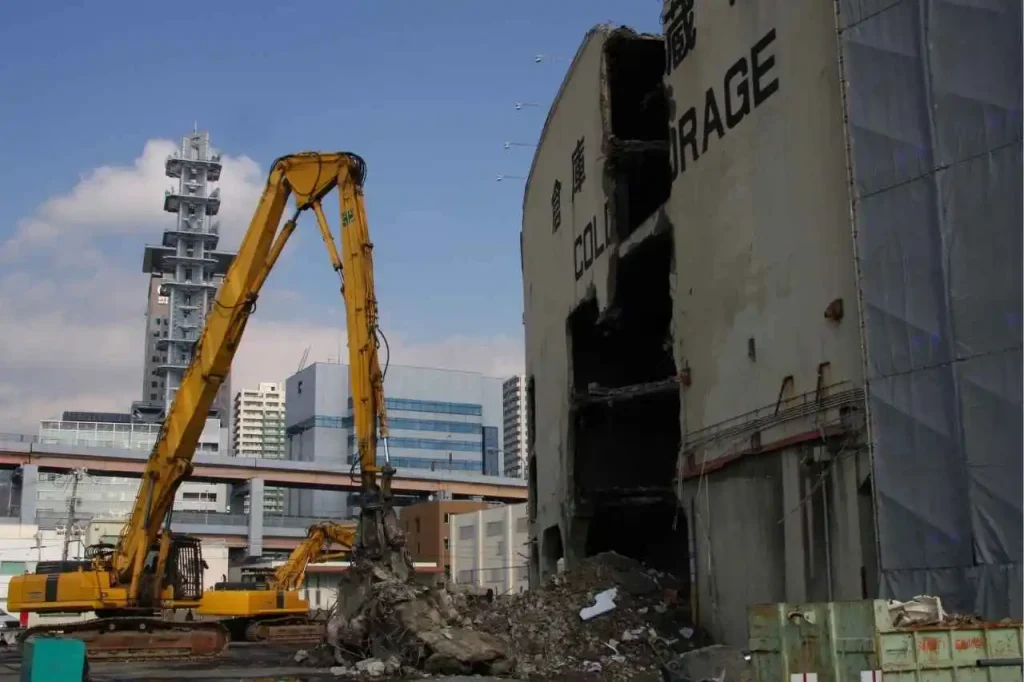 Heavy excavator tearing down multi-storey industrial building during demolition project in Pascoe Vale Victoria.