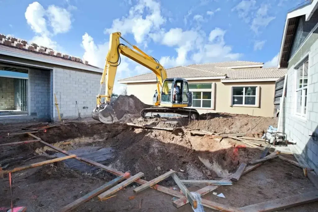 Excavator excavating backyard foundation area for residential construction project in Pascoe Vale VIC.
